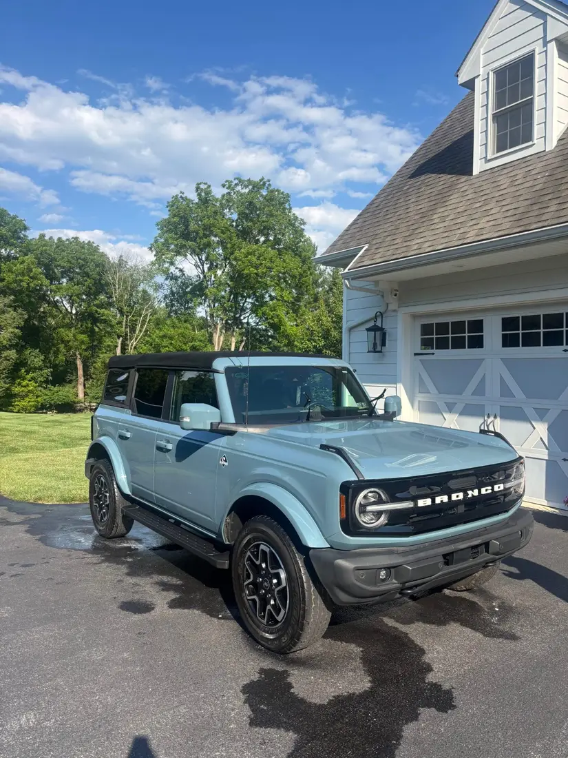 Cactus-gray Ford Bronco freshly detailed in a client driveway